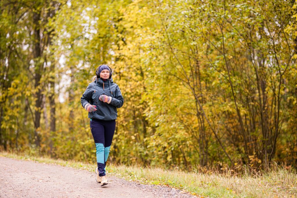 A woman jogging in the autumn landscape.